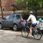 Parent and child riding bike on street